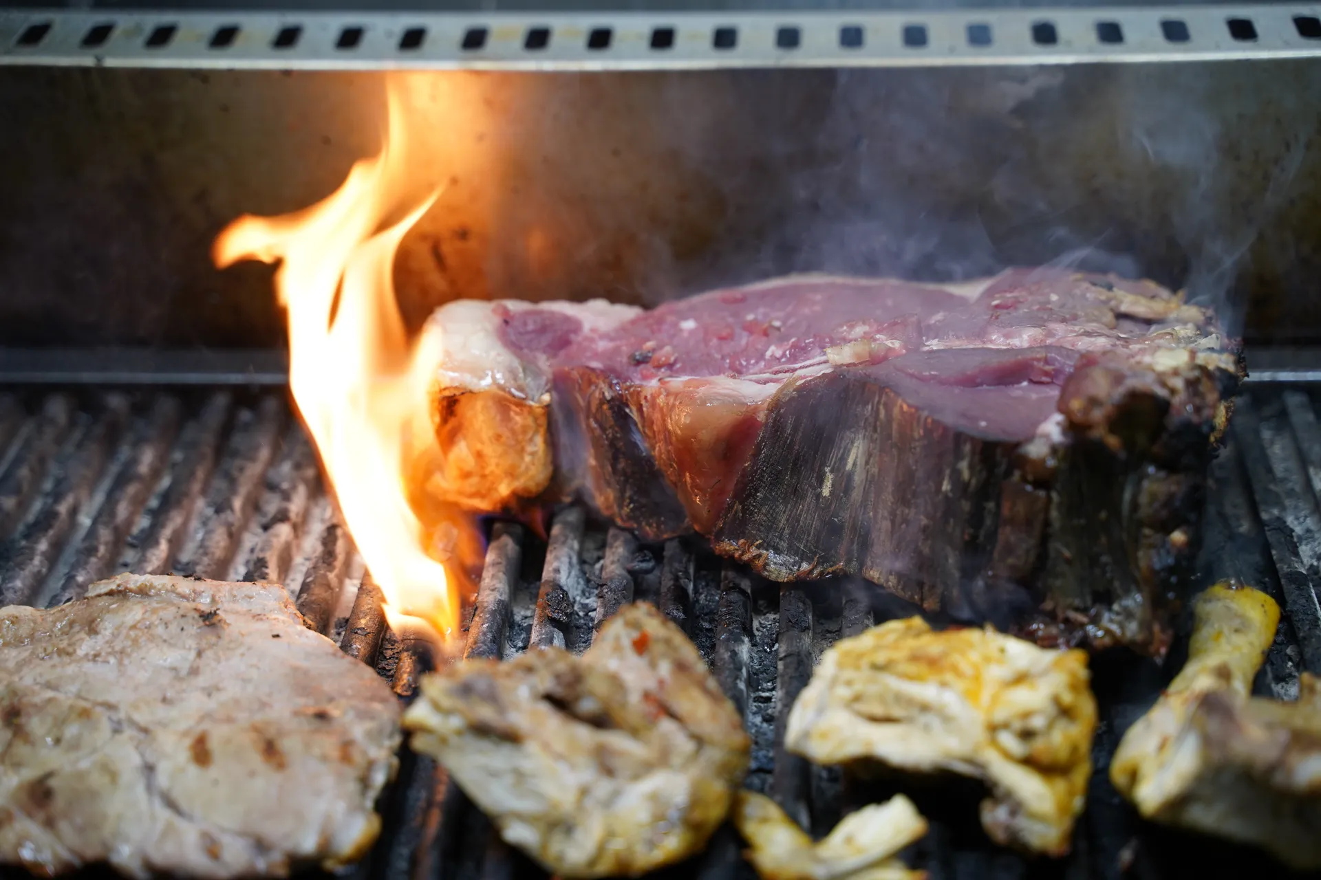 Bistecca in cottura sulla griglia a fiamma viva