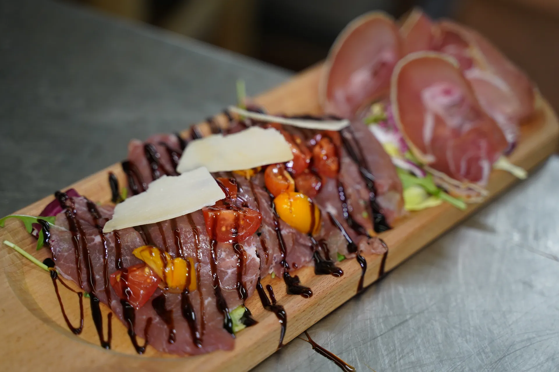 Tagliata di manzo con pomodorini, scaglie di grana e glassa all’aceto balsamico