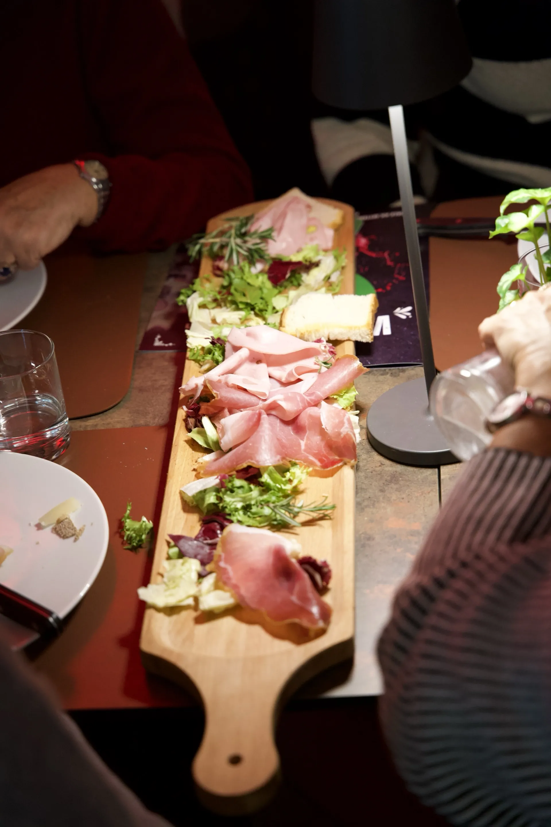 Tavolata conviviale con tagliere di salumi e formaggi toscani